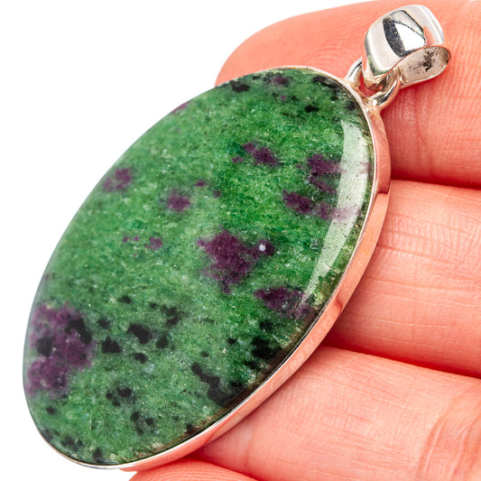 Ruby zoisite pendant close-up, teardrop green cabochon with purple flecks, silver setting