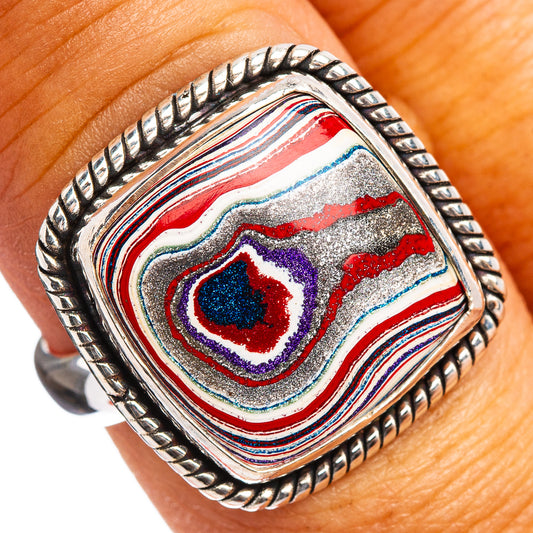Sterling silver oval ring with multicolor fordite stripes and dark blue/red center stone