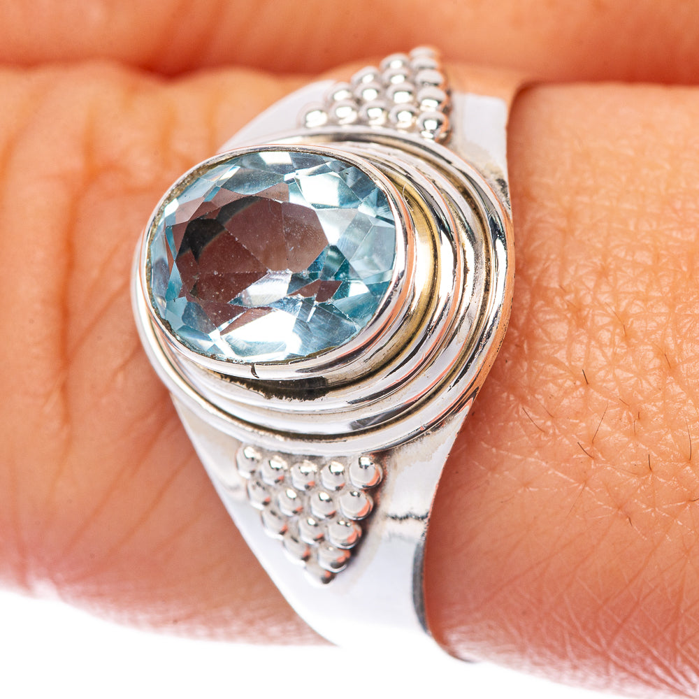 Sterling silver ring with blue round gemstone and swirl setting, size 9