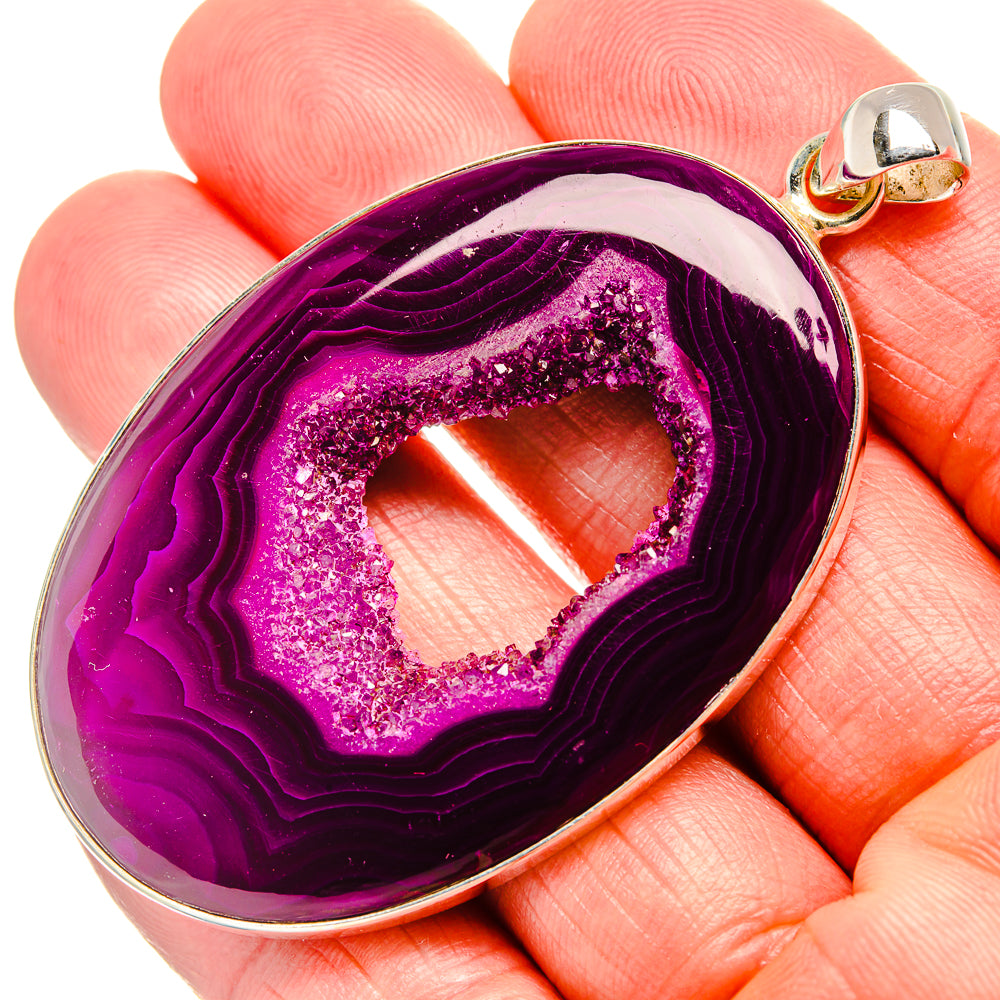 Purple drusy teardrop window pendant with silver bail, held in hand
