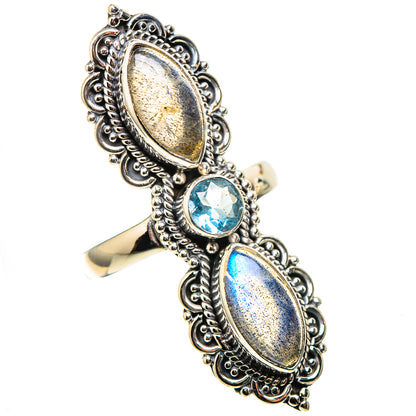 Ornate silver ring featuring two oval labradorite stones and a round blue topaz