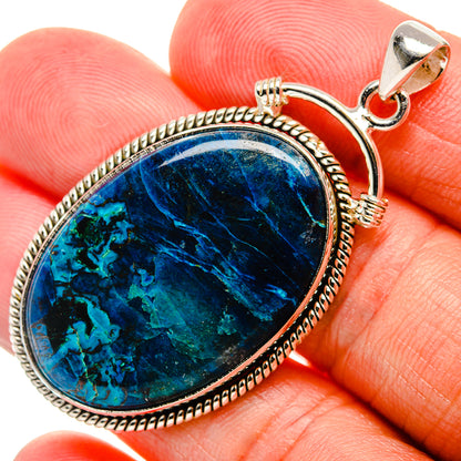 Blue teardrop shattuckite pendant with sterling silver frame and top bail in hand