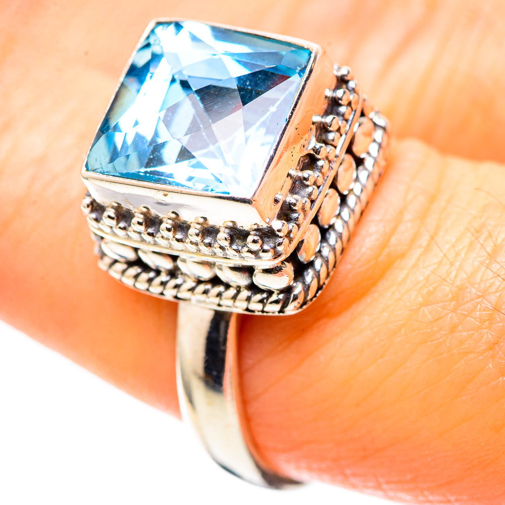 Sterling silver ring with blue topaz cushion-cut gemstone in detailed bezel frame