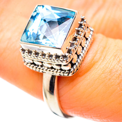 Sterling silver ring with blue topaz cushion-cut gemstone in detailed bezel frame