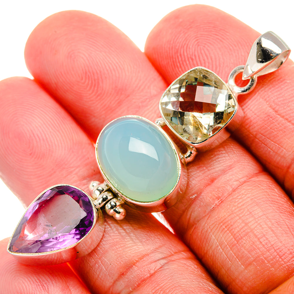 Close-up sterling silver pendant with purple teardrop, oval aqua, and faceted yellow stone