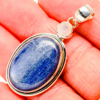 Sterling silver oval pendant with blue cabochon and round pale stone accents