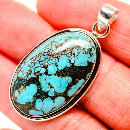 Oval turquoise pendant with black matrix, bezel-set in silver bail