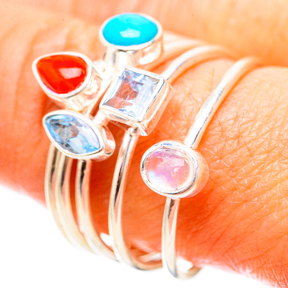 Silver-tone ring with red teardrop, square clear, oval blue, and round pink stone settings
