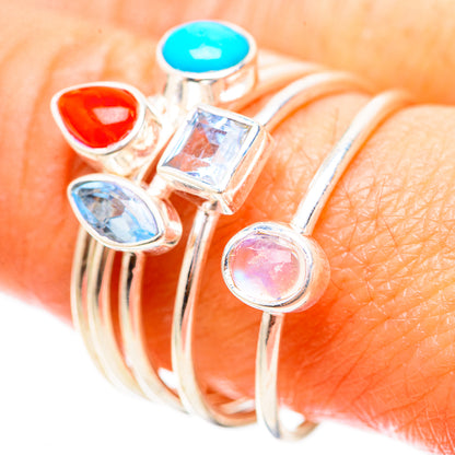 Silver-tone ring with red teardrop, square clear, oval blue, and round pink stone settings