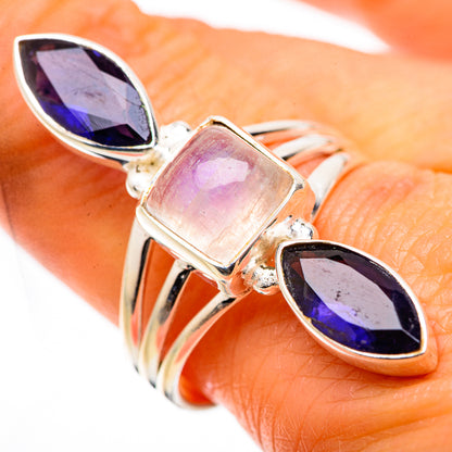 Sterling silver ring on finger with square rainbow moonstone and two oval purple stones