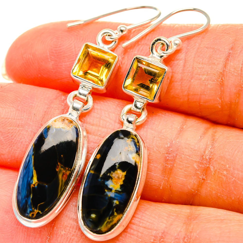Close-up dangle earrings: square yellow citrine and oval pietersite cabochons on silver