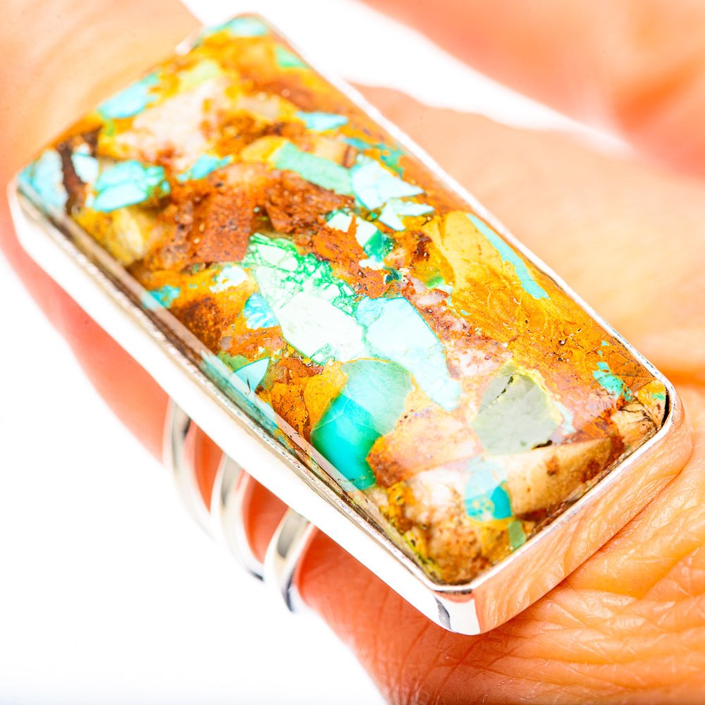 Turquoise and brown stone inlay rectangular ring on finger, sterling silver band