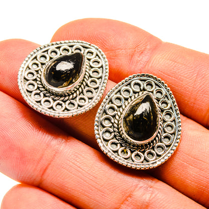 Silver filigree teardrop earrings with dark green gemstone cabochon, close-up