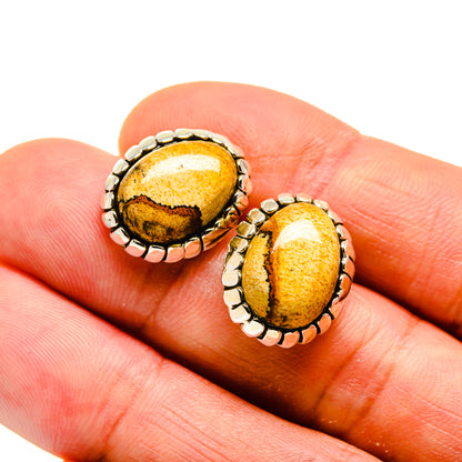 Oval picture jasper stud earrings on hand: yellow-brown stone with scalloped 925 sterling silver bezel
