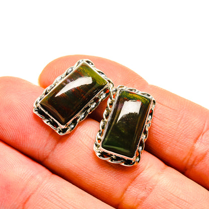 Square green gemstone earrings with silver scalloped bezel, close-up on stones