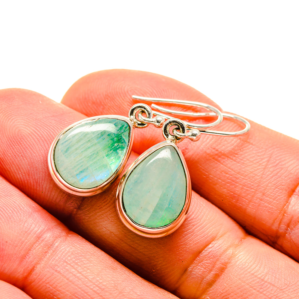 Moonstone earrings with pear-shaped green/teal stones and silver-tone bezel, close-up