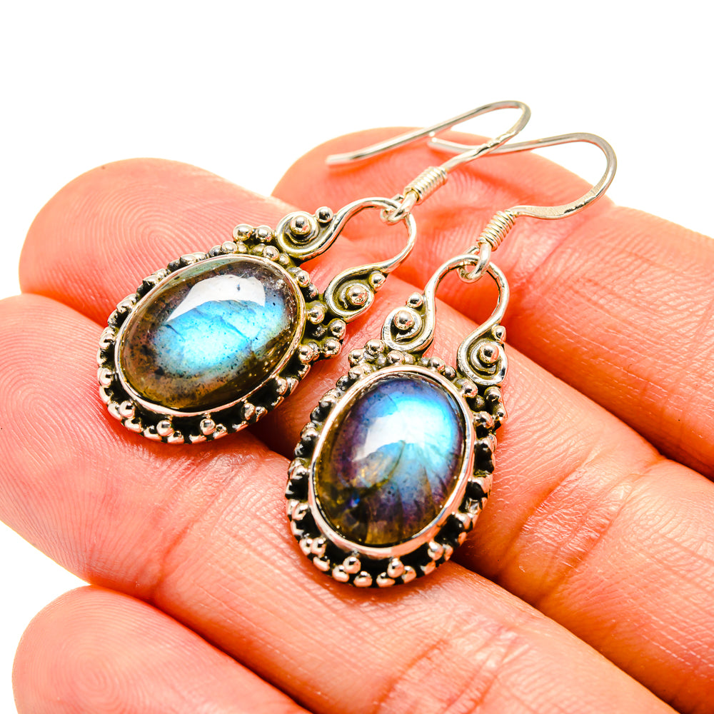 Oval labradorite drop earrings in sterling silver, close-up with blue-gold stone glow