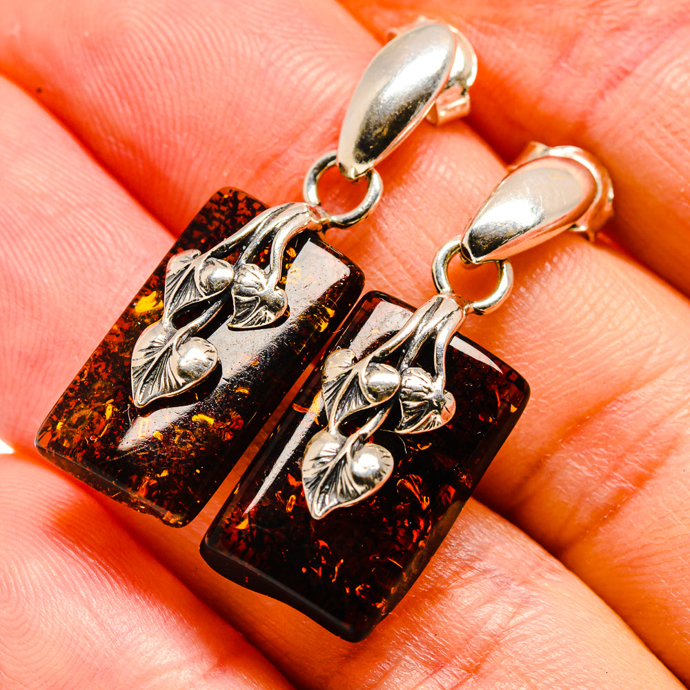 Amber dangle earrings with silver floral charms and dark orange rectangular panels