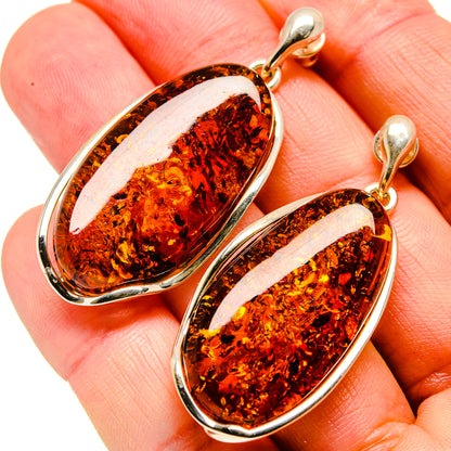 Amber oval drop earrings with dark speckled amber and silver-tone hinged hoops