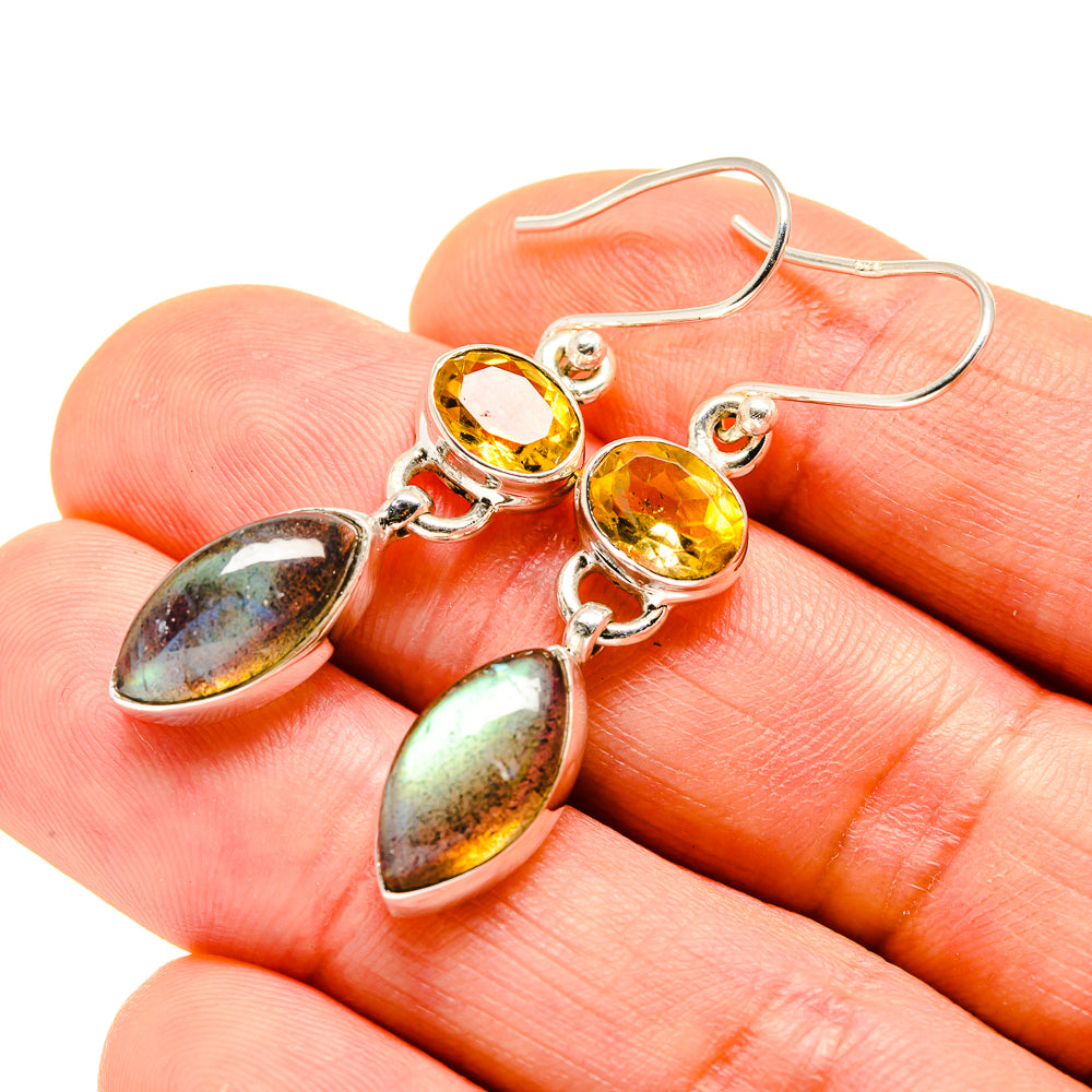 Close-up of 925 sterling silver earrings with yellow citrine and iridescent labradorite drops