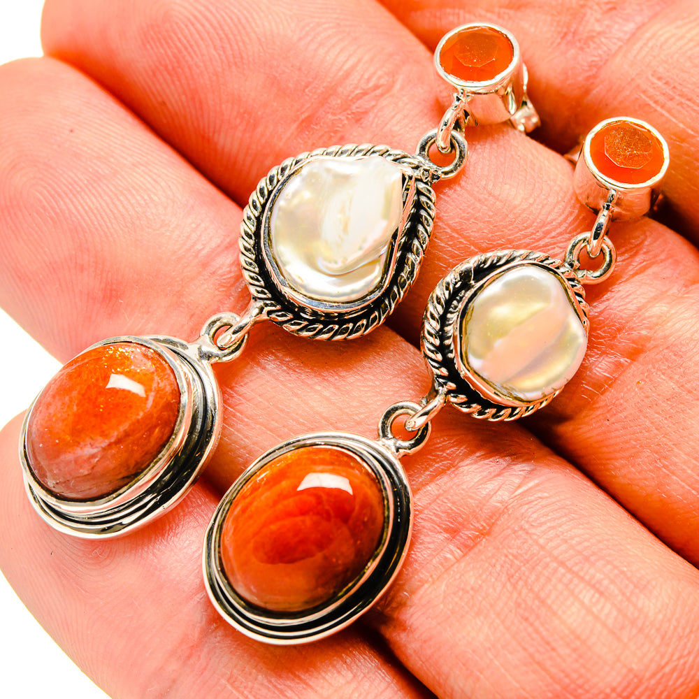 Sterling silver dangling earrings with orange carnelian and iridescent mother-of-pearl discs