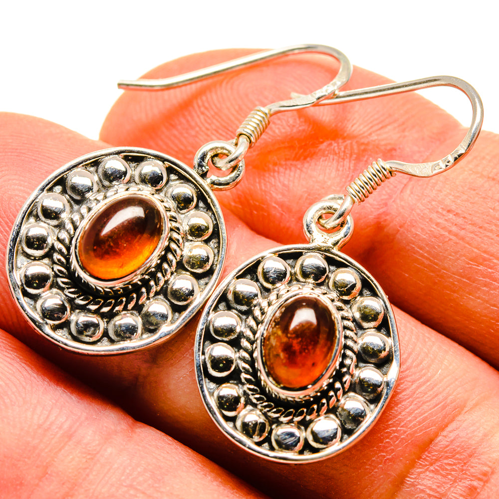 Oval-orange carnelian cabochon earrings in silver-tone ornate settings, fishhook