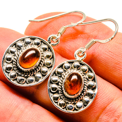 Oval-orange carnelian cabochon earrings in silver-tone ornate settings, fishhook