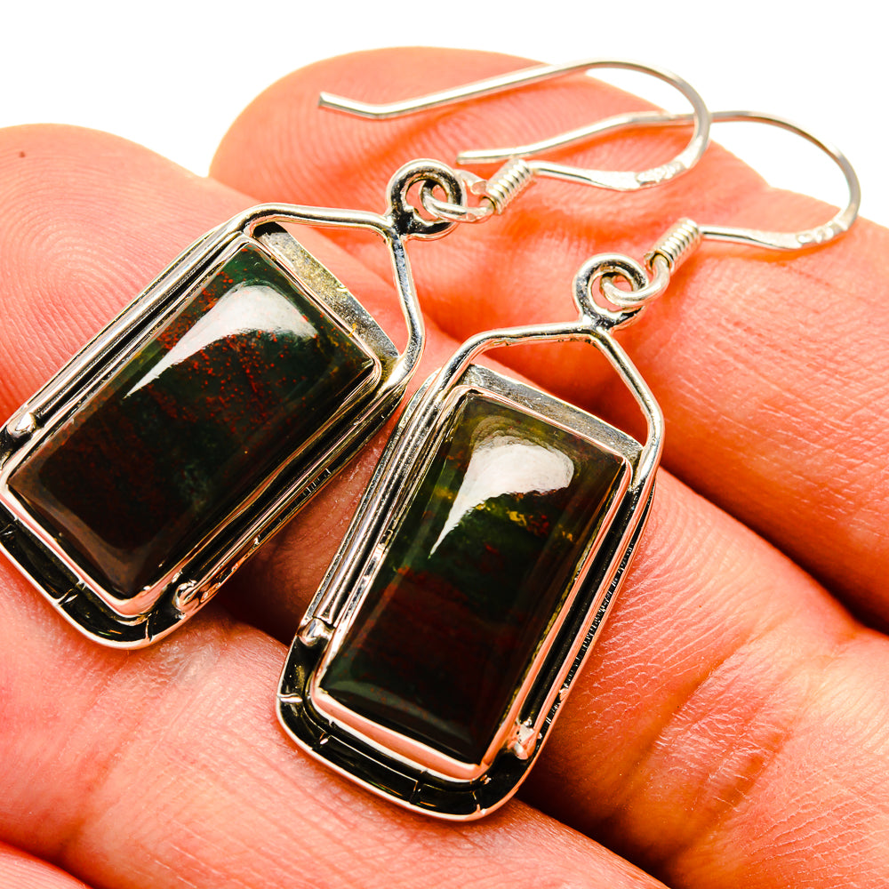 Close-up of bloodstone cabochon drop earrings, dark green and red in framed bezels