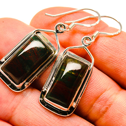 Close-up of bloodstone cabochon drop earrings, dark green and red in framed bezels