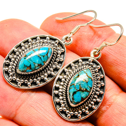 Turquoise cabochon oval drop earrings on silver-tone scalloped frame with gold hooks