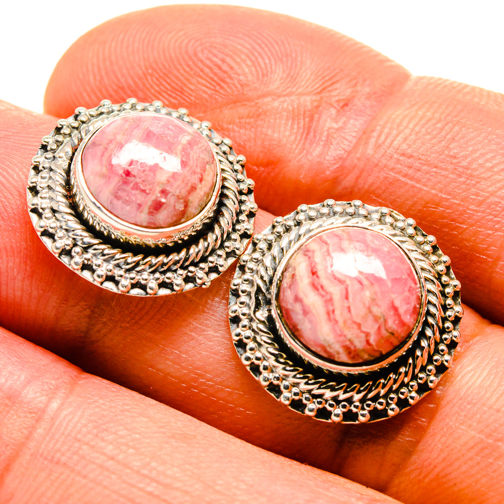 Oval rhodochrosite pink cabochon earrings with textured silver border, close-up
