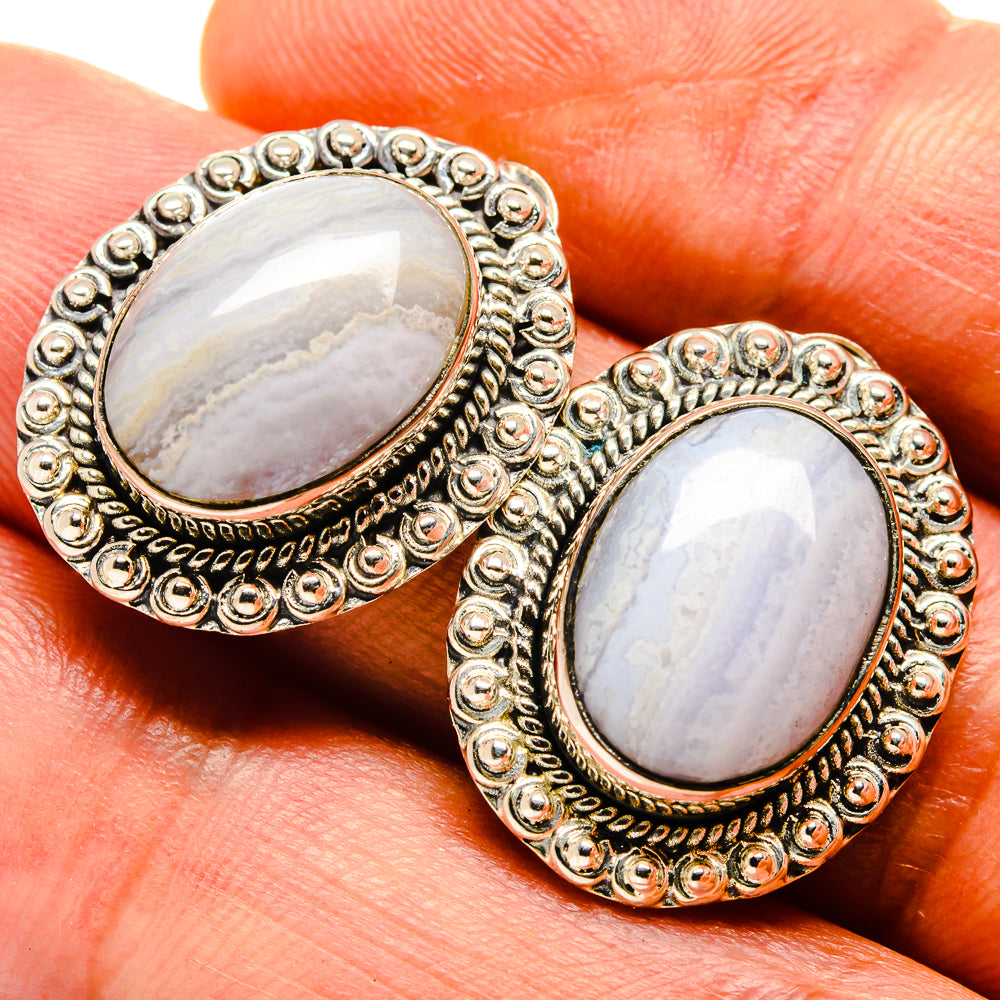 Oval stone earrings close-up with textured filigree bezel and gold-tone frame
