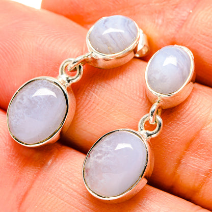 Gold-tone drop earrings with two light lavender oval stones and silver ear hooks