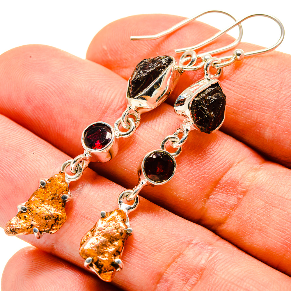 Close-up of garnet and copper blister dangle earrings on silver links, round cabochons