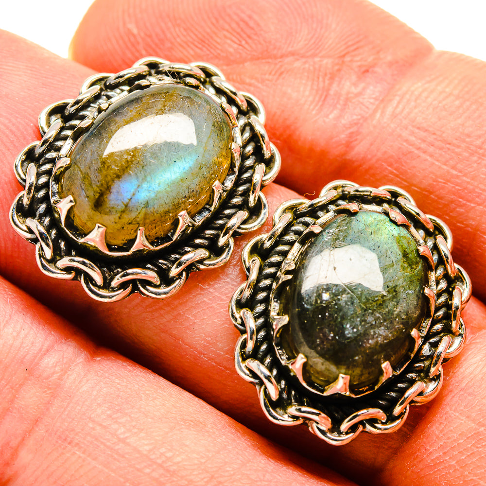 Close-up of labradorite stud earrings with oval cabochon in braided silver settings