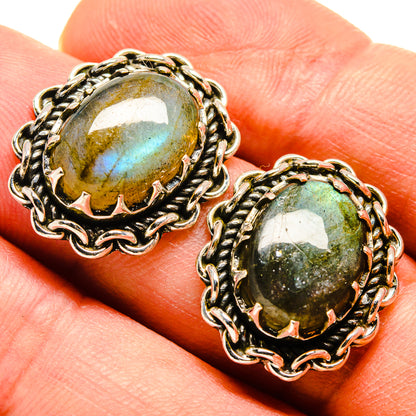 Close-up of labradorite stud earrings with oval cabochon in braided silver settings