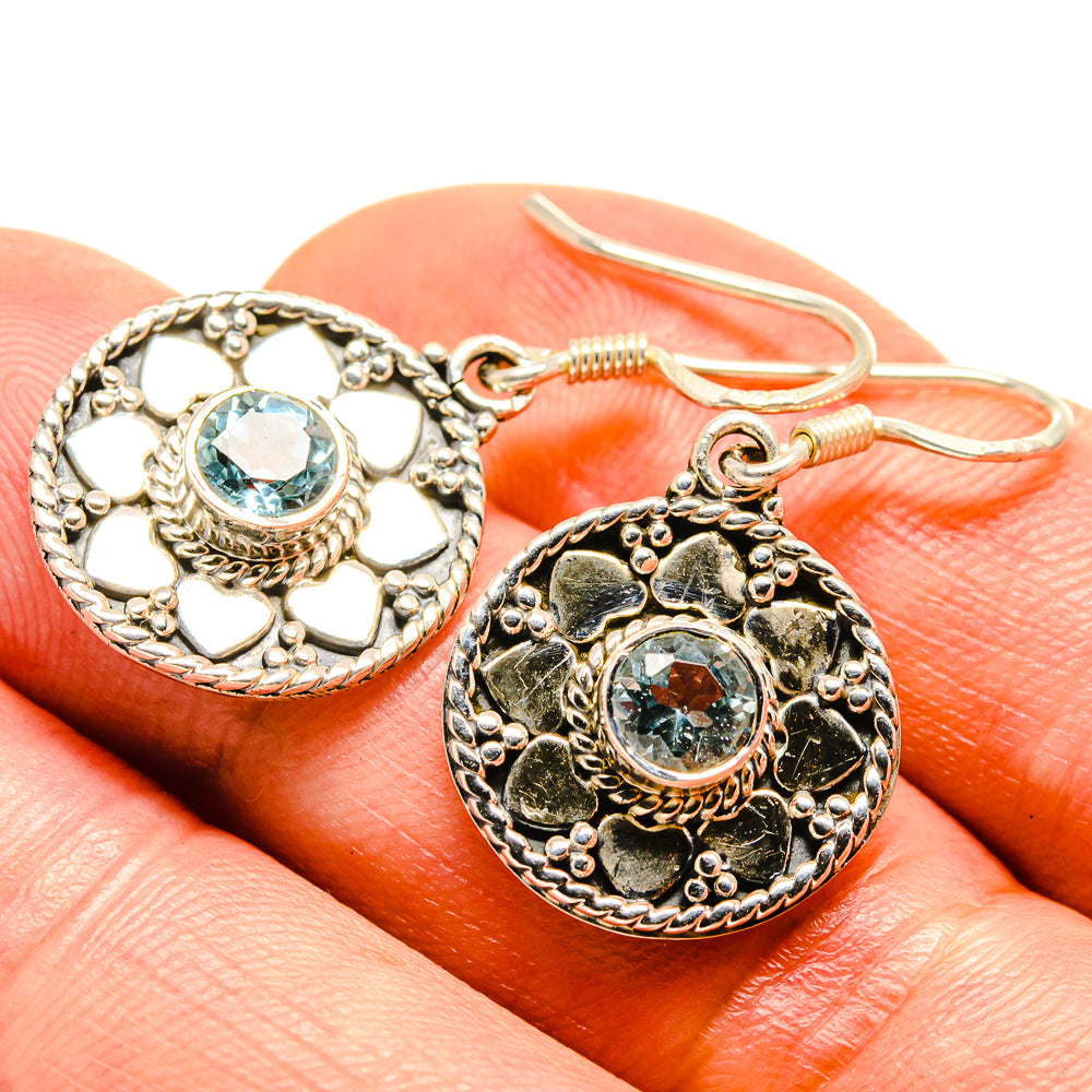 Ornate sterling silver drop earrings with round blue topaz-style gemstone and heart scrollwork