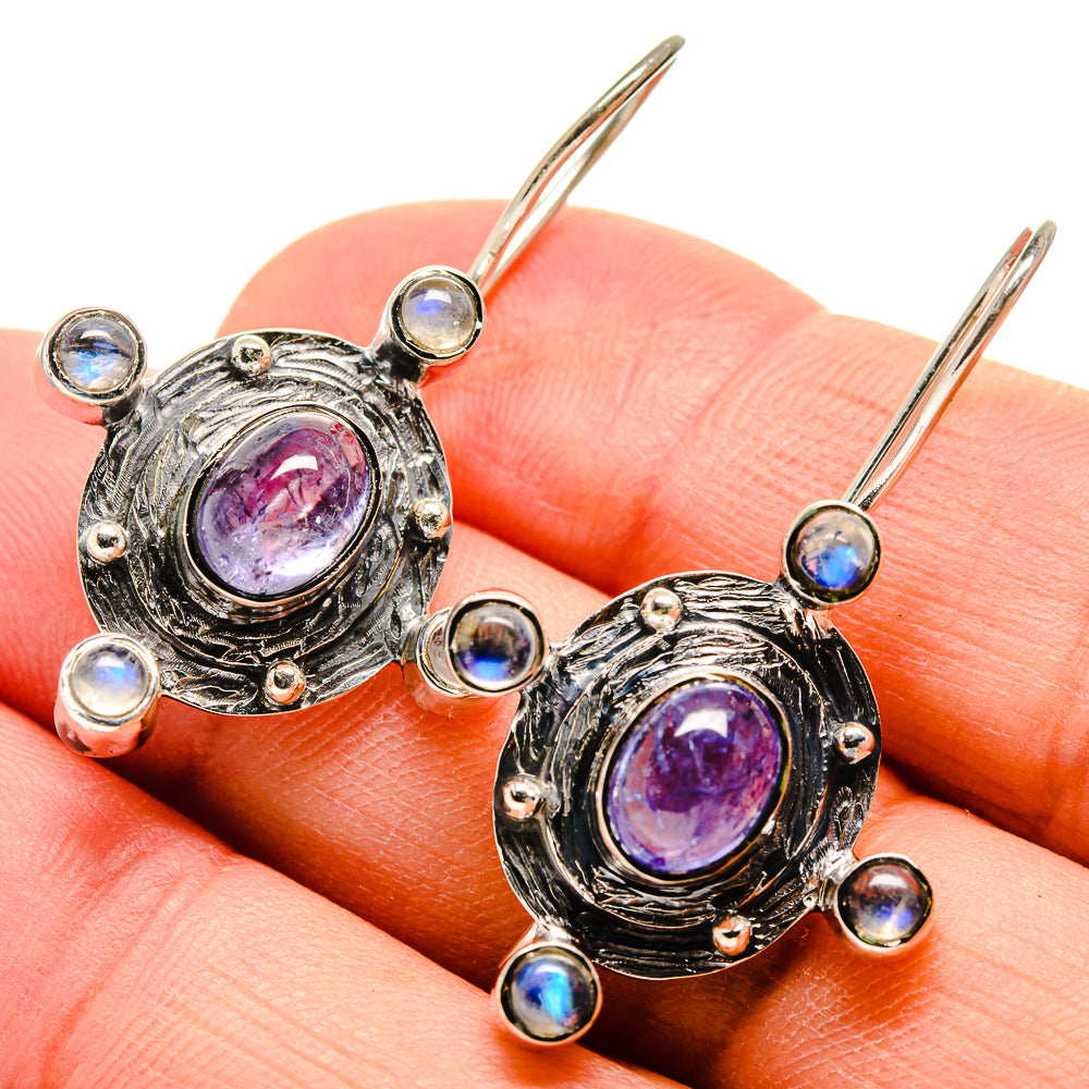 Silver-tone oval drop earrings with purple tanzanite center and blue moonstone halos, lever hooks