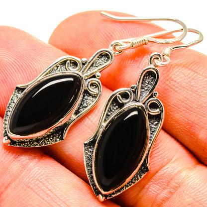 Onyx oval dangle earrings with textured silver-tone bezel and fishhook closure