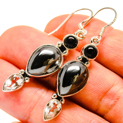Silver-tone earrings with black round stones, oval drops, and clear teardrop accents