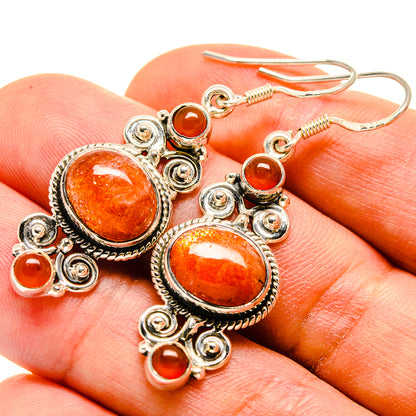 Carnelian earrings with oval orange cabochon, silver-tone filigree and small drop accents