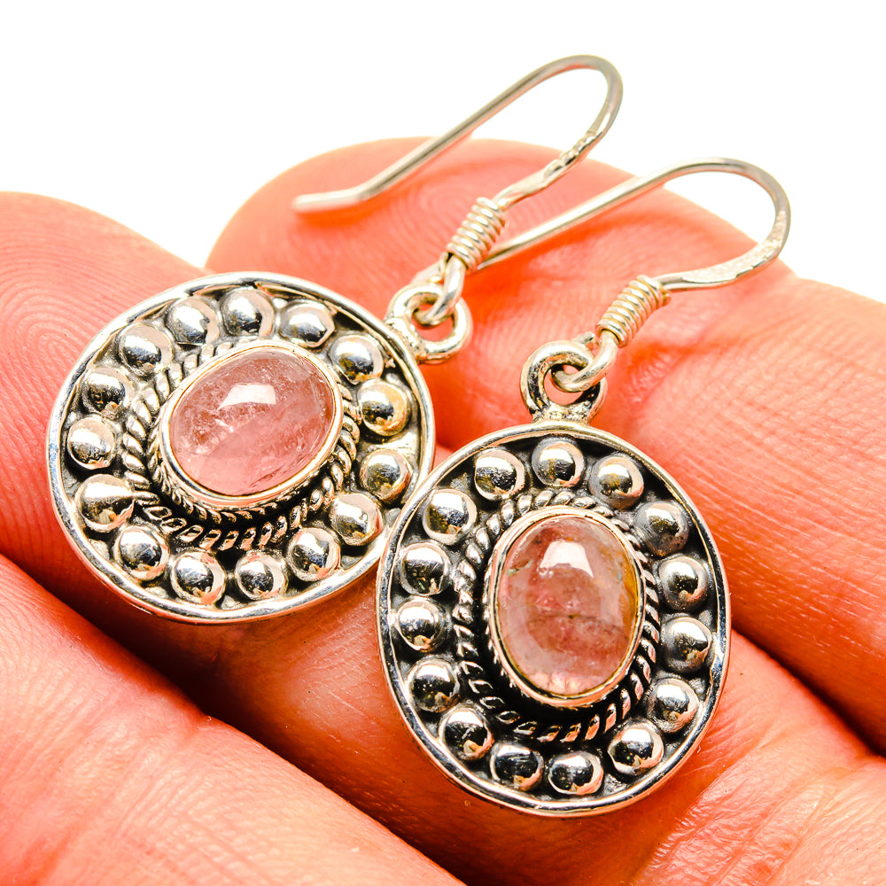 Oval rose quartz earrings with ornate beaded bezel, pink cabochon, and fishhook closures