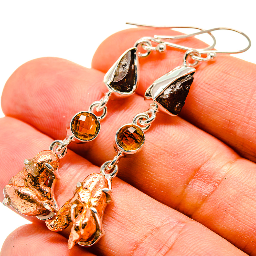 Dangle earrings with silver-tone chain, dark copper teardrop pieces, and amber round stones