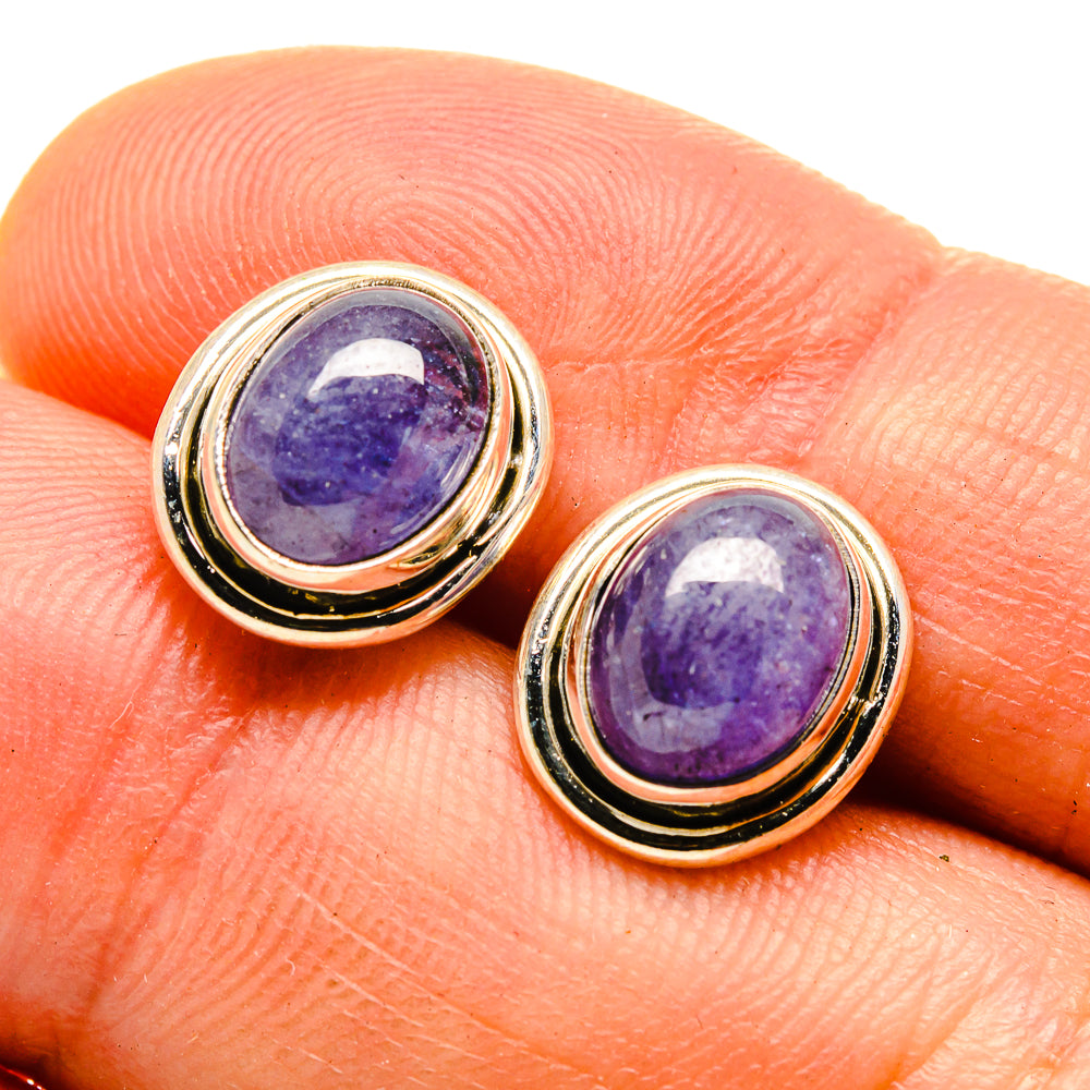 Oval purple gemstone stud earrings with gold-tone double bezel, close-up
