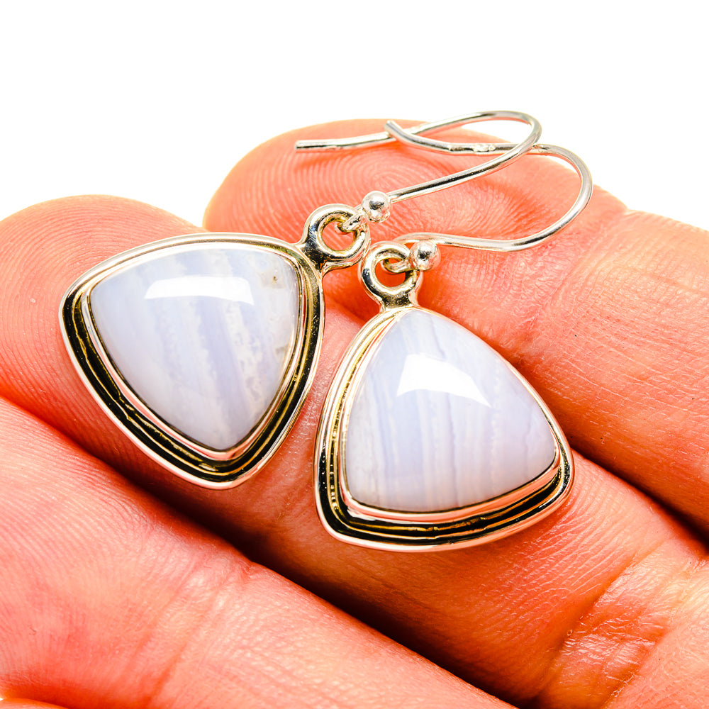 Silver-tone earrings with hooked backs and bezel-set opalescent pale blue/white stones