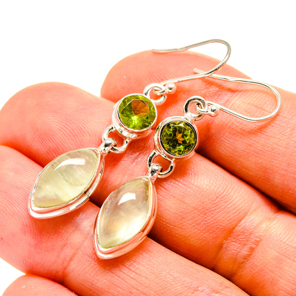 Sterling silver earrings close-up: peridot-green round stones with pale green oval drops