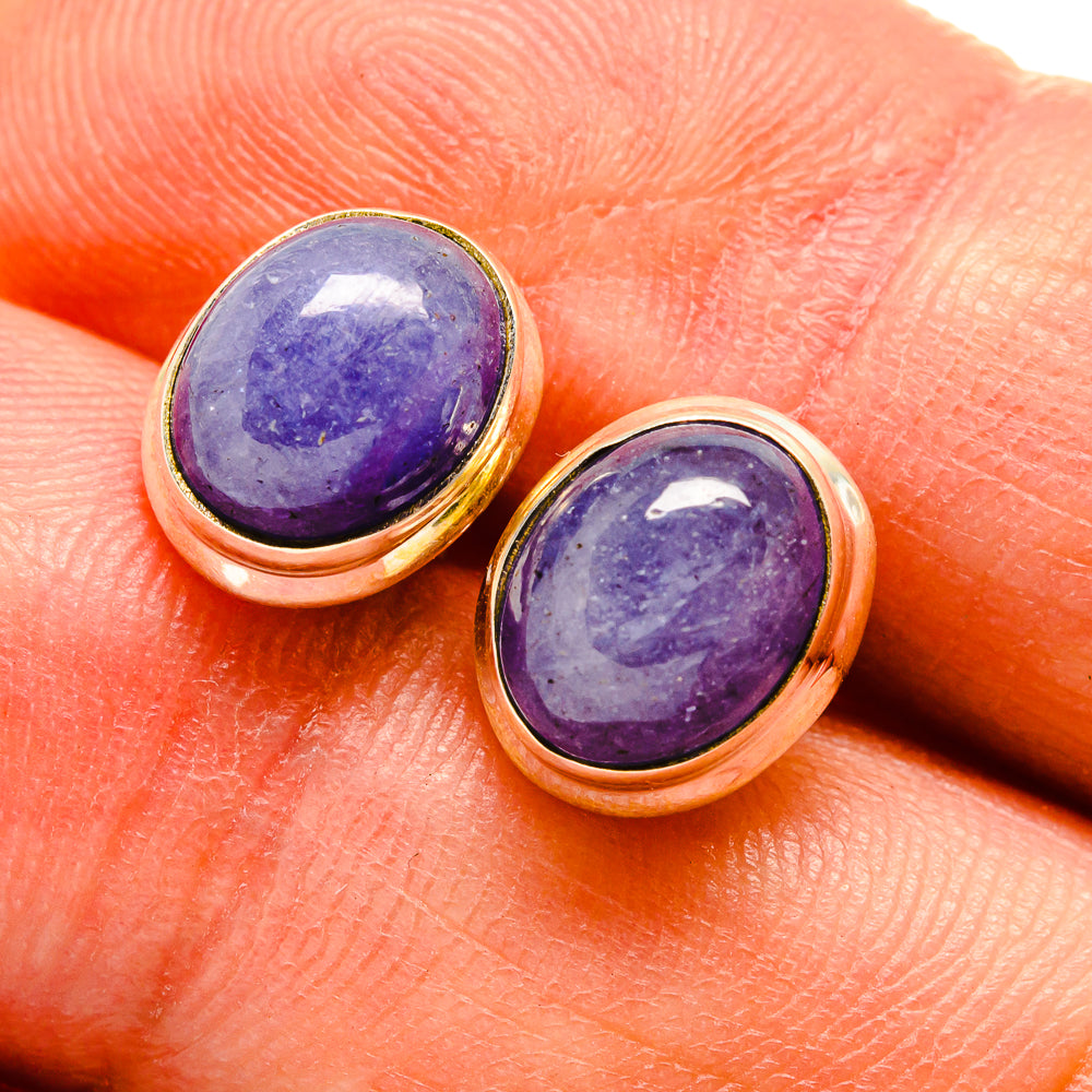 Oval tanzanite stud earrings with purple gemstone cabochons in gold-toned bezels