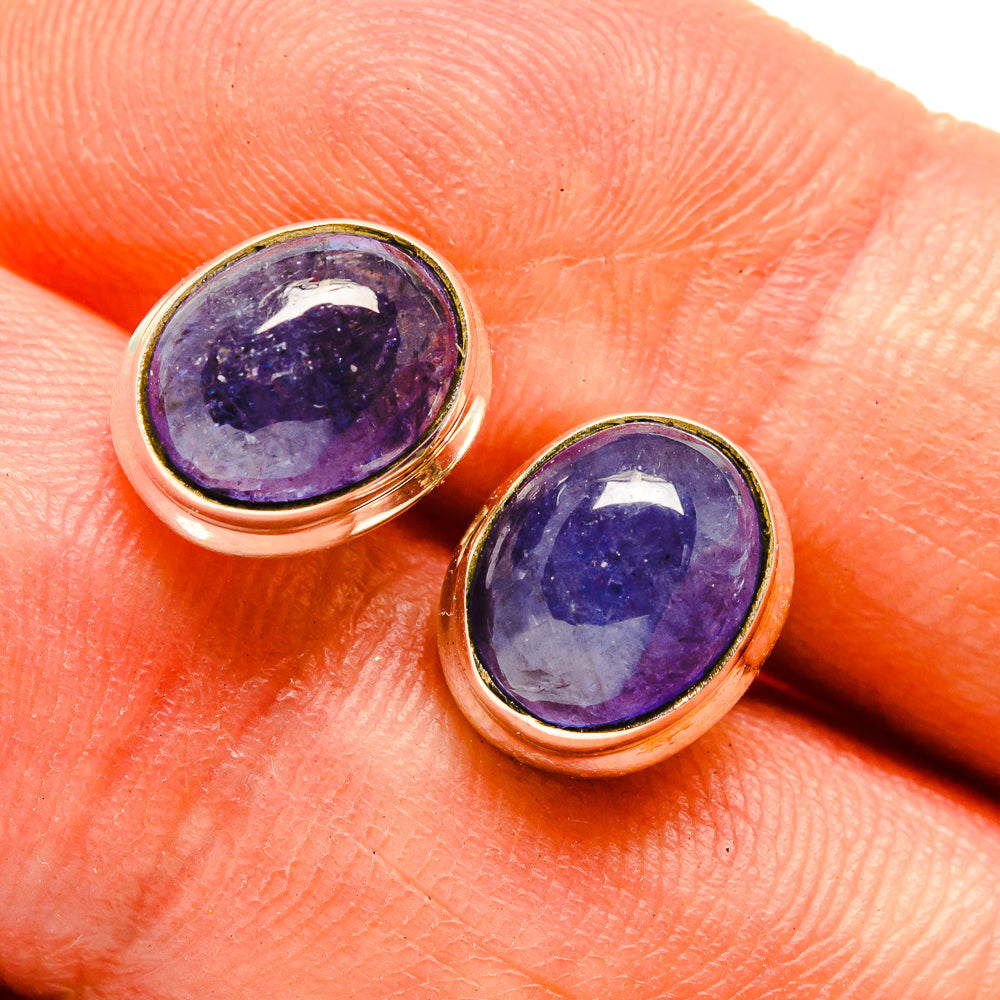 Close-up oval tanzanite cabochon earrings with purple gemstone in 925 silver bezels