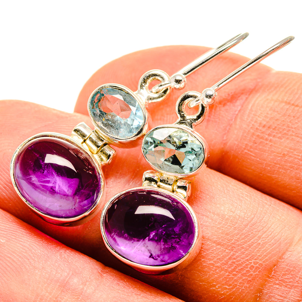 Close-up of 925 sterling silver drop earrings: oval purple amethyst and aqua blue topaz stones