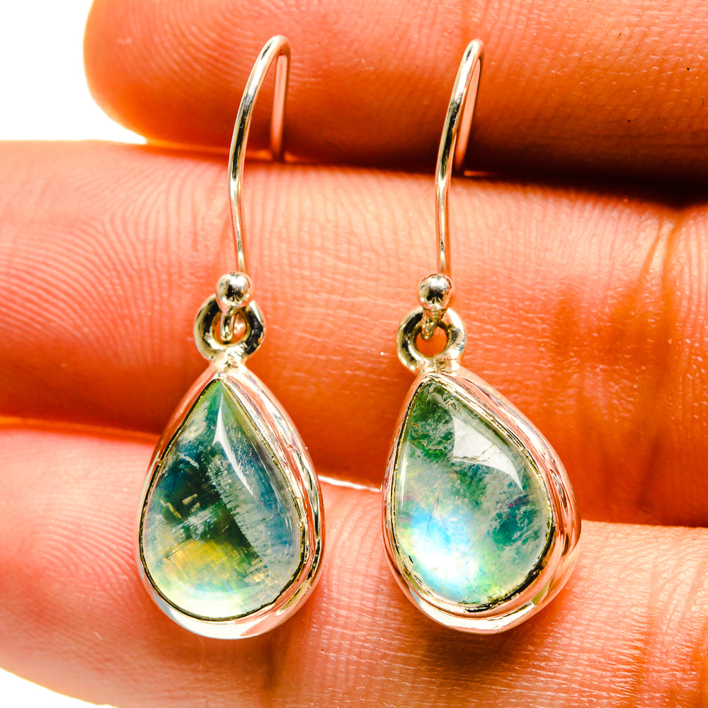 Green teardrop moonstone earrings with silver hooks, close-up